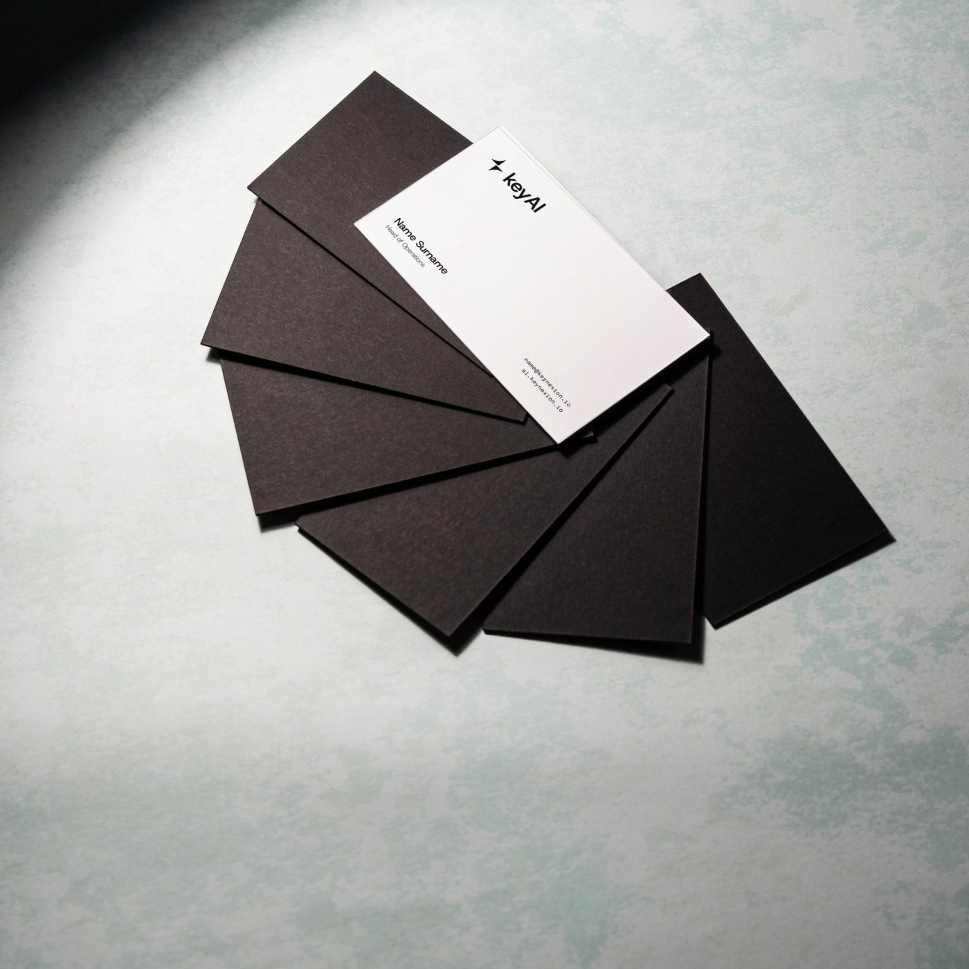 Fan of black business cards with one white keyAI card on top